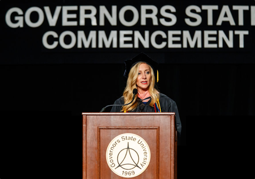 Cristy Gallegos, a GovState alumni, standing at a podium and giving a speech at the 2019 GovState commencement ceremony