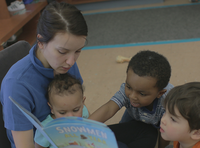 FDC staff member reading book to children