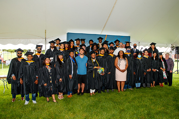 Dr. Green with graduates at outdoor celebration