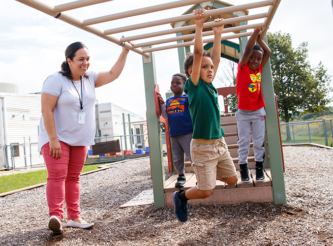 FDC staff member watching children play