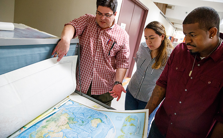 Professor looking at map with students