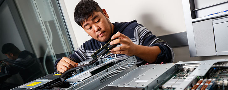 Male Student swapping out internal hardware components in computer equipment Male Student swapping out internal hardware components in computer equipment