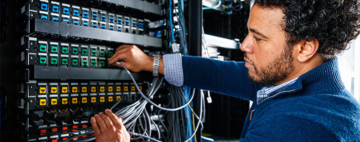 Male Student Working at Network Patch Panel Male Student Working at Network Patch Panel