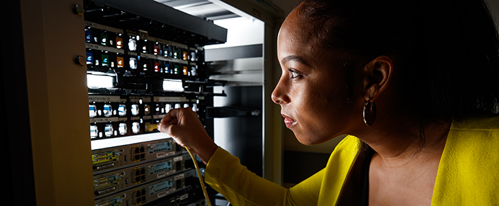 Student plugging cable into switchboard