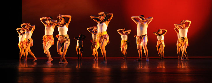 group of dancers with red background lighting