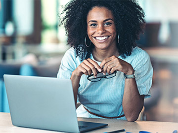 student smiling with laptop in front of her