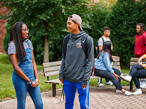 Students talking outside by benches