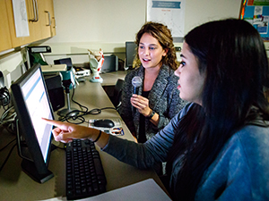 Students using a computer and microphone