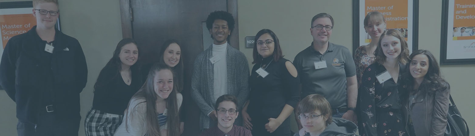 Students standing and smiling in hallway