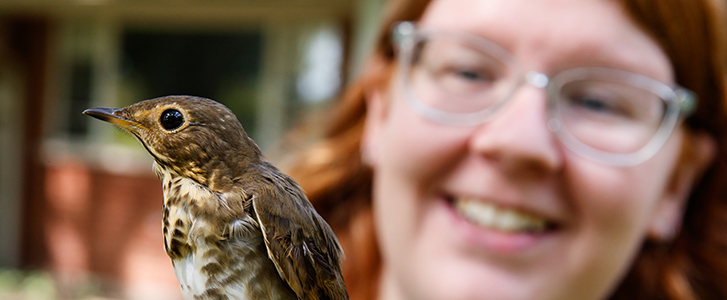 Student holding bird Student holding bird