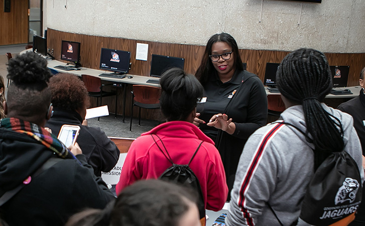 Staff member talking to students at Open House