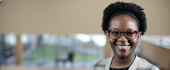 Student smiling on staircase in Hall of Governors