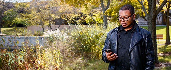 Student looking at phone outside Student looking at phone outside