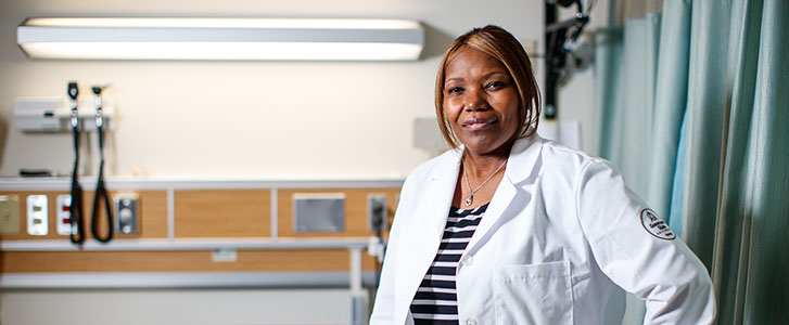 University nurse smiling in patient room