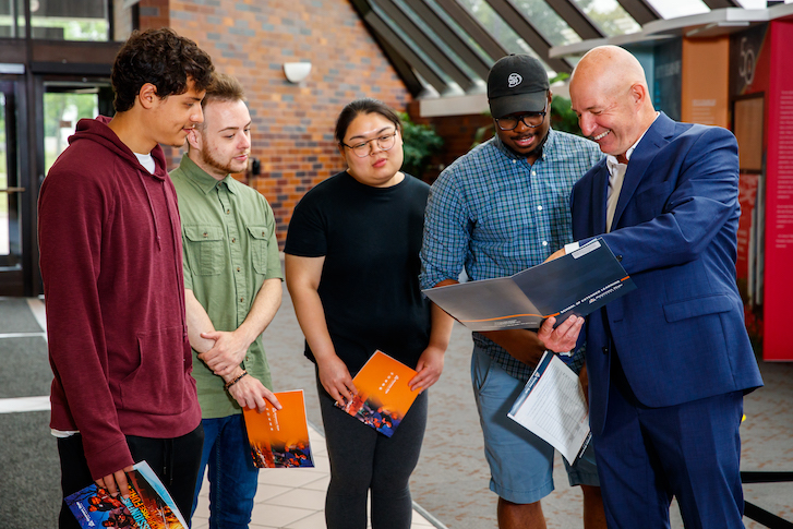 Admissions counselor showing student transfer guide