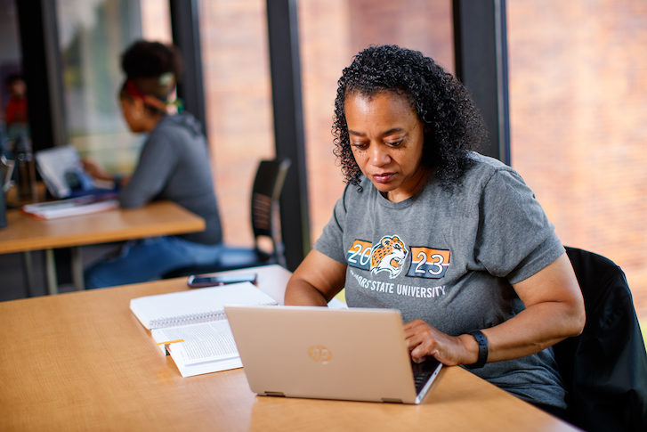 Student typing on laptop Student typing on laptop