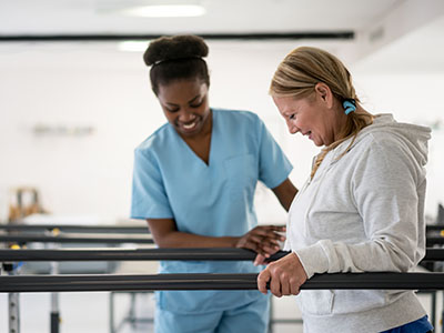 patient with Occ Therapist and parallel bars