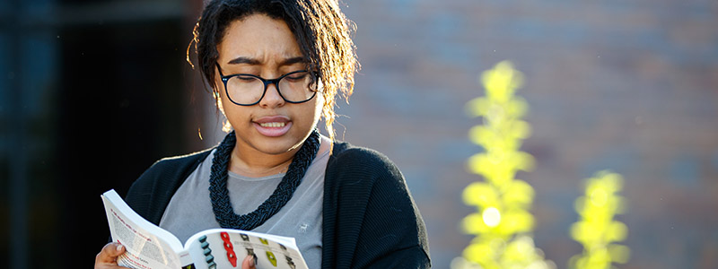 student reading English literature outdoors