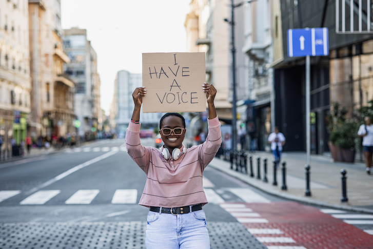 Person holding up sign in city street