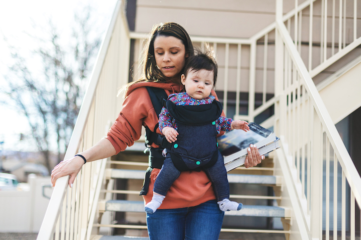 Parent walking down stairs while carrying baby