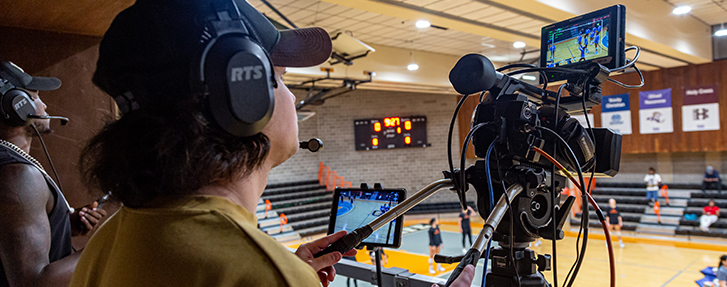 People recording video of a sports event