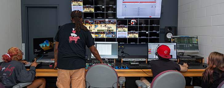 SportsInternship_Contact_Us A group of people at a desk in a studio