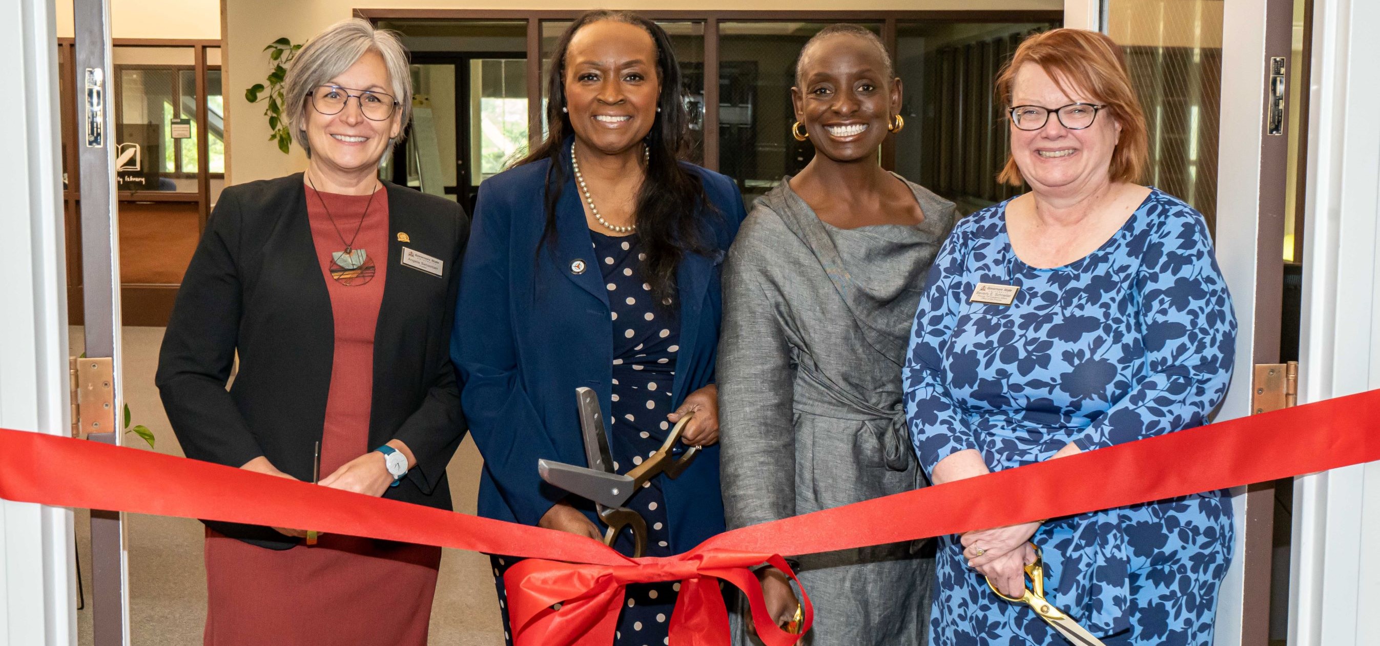Dr. Green cutting ribbon with Chair Sebastian, Dr. West, and Dr. Schneller at Legal Clinic opening event