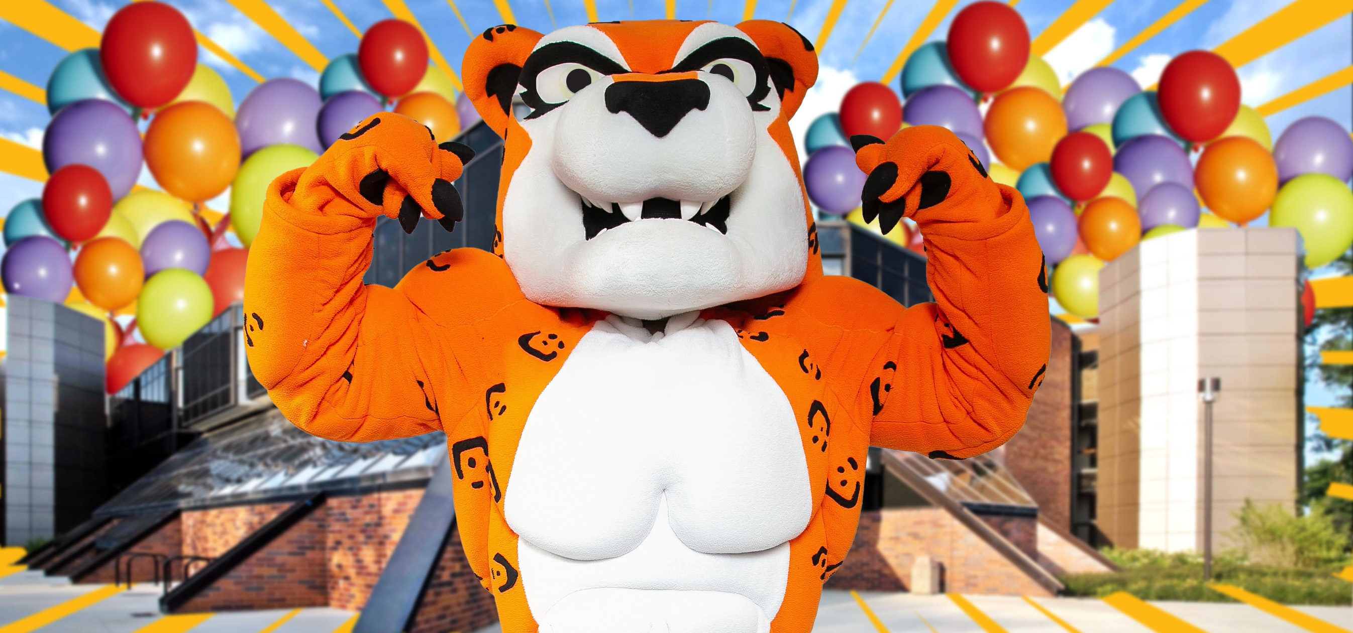 Jax flexing in front of GSU entrance with balloons in the sky