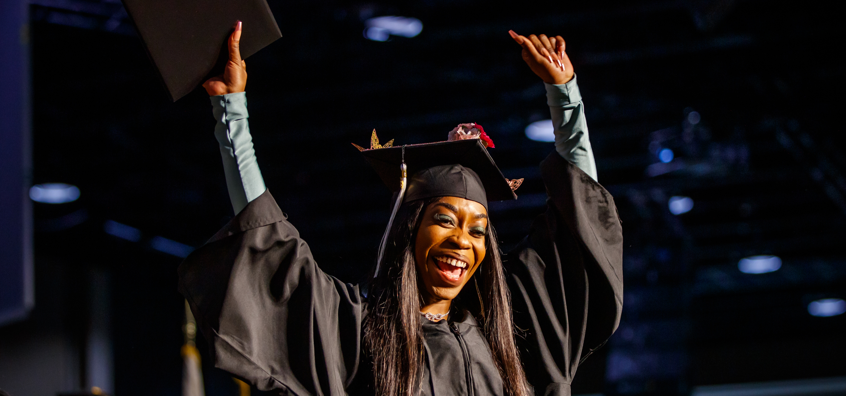 Graduate at 2023 Commencement celebrating on stage with degree
