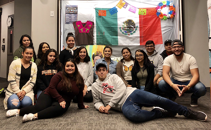 Students huddle around Latinx Heritage Month display