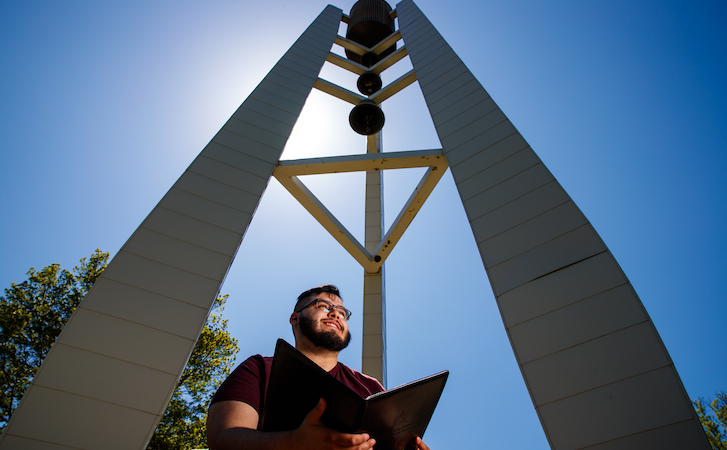 Student sitting underneath GovState belltower