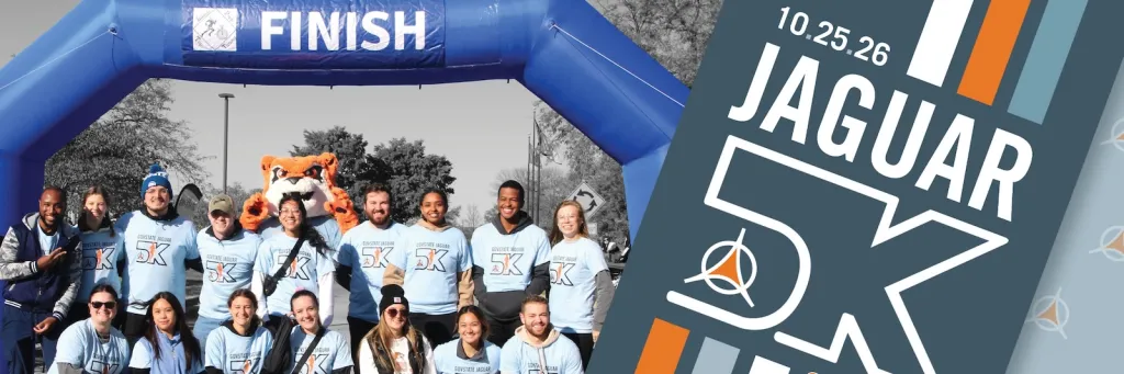 A group of people with Jax under a blue finish line arch, next to a Jaguar 5K graphic.
