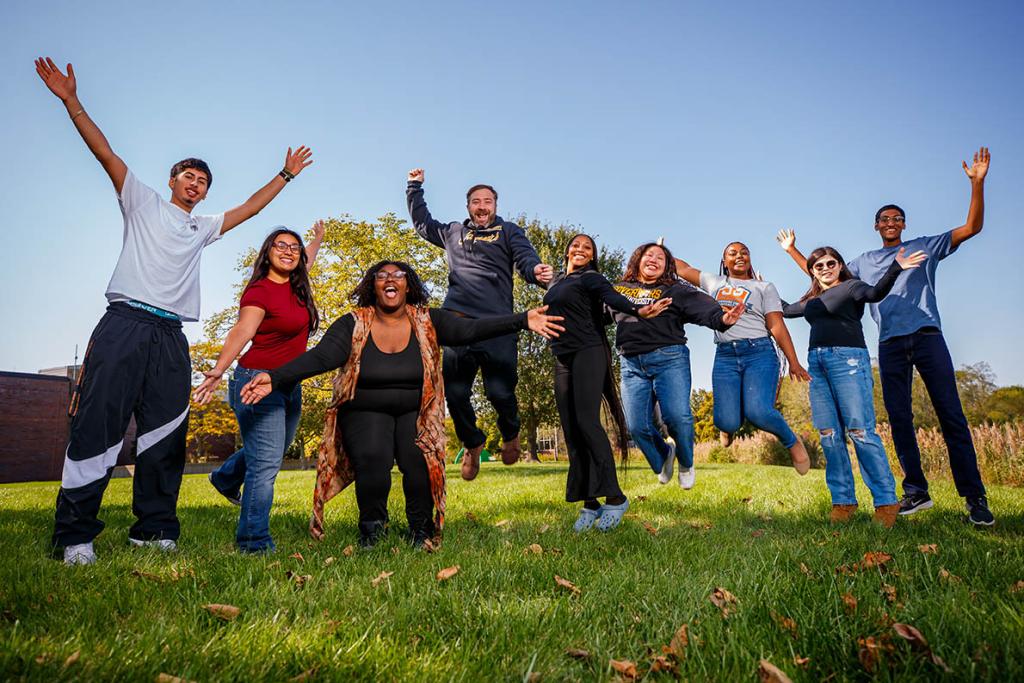 A group of people smiling and jumping in the air