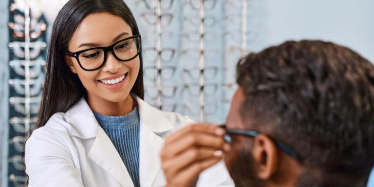Optician fitting a patient with glasses