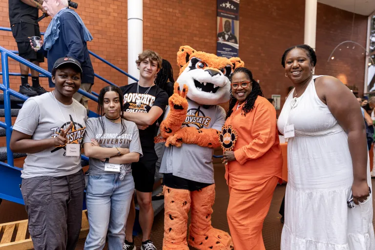 A group of students smiling with Dr. Joyce Ester at GovState's 56th Birthday Party