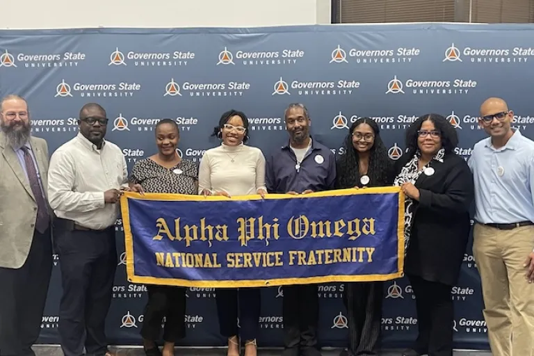 Alpha Phi Omega members holding banner