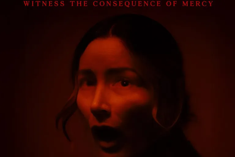 Horrified woman in dark red light, looking over her shoulder.