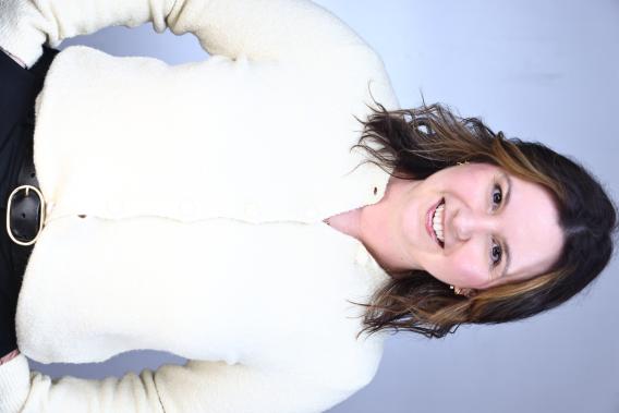 Professional headshot, woman with shoulder-length brown hair, wearing a white blouse. 