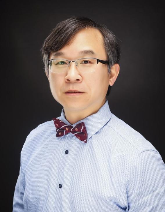 Headshot of an Asian man wearing glasses, a blue shirt, and a striped bow tie.