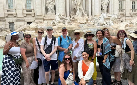 Honors College students and faculty posing together at the Trevi Fountain during a faculty-led study abroad experience in Italy.