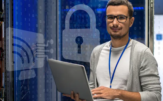 Computer Technician with Laptop in Computer Server Room
