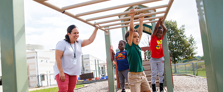 FDC team member watching kids play on playground