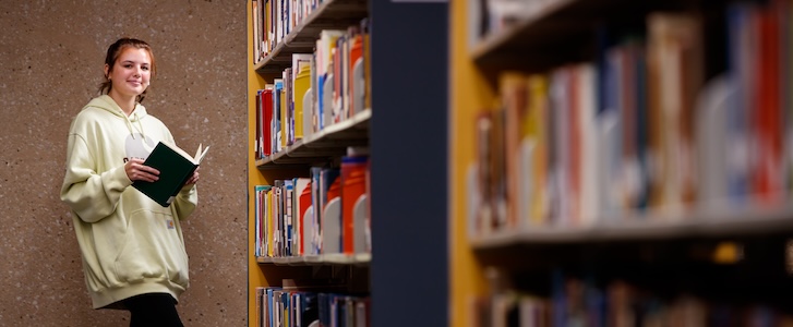 Student reading book in library